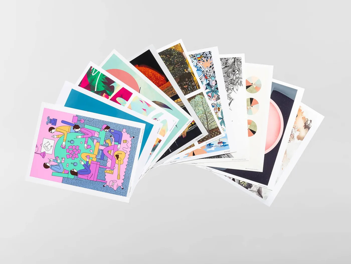 A fan of printed postcards spread across a grey surface